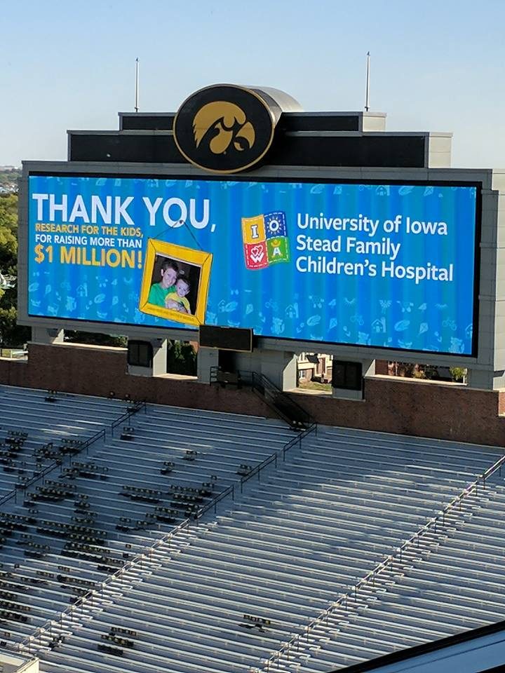 The Kinnick Stadium scoreboard reading: Thank you, Research For The Kids, for raising more than $1 million, beside the University of Iowa Stead Family Children's Hospital logo